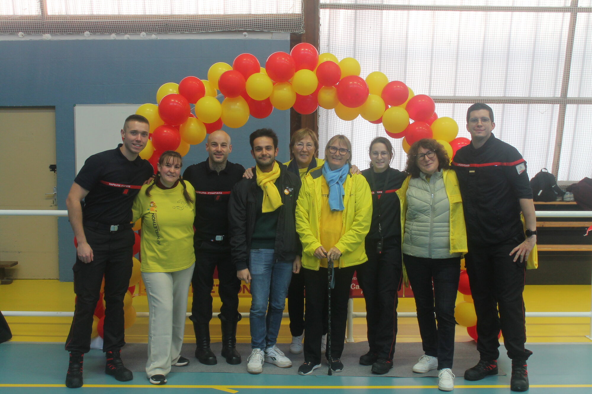 Sapeurs-pompiers et bénévoles du Téléthon réunis sous l'arche de ballons lors de la 1ère édition du Challenge Téléthon à Montlouis-sur-Loire