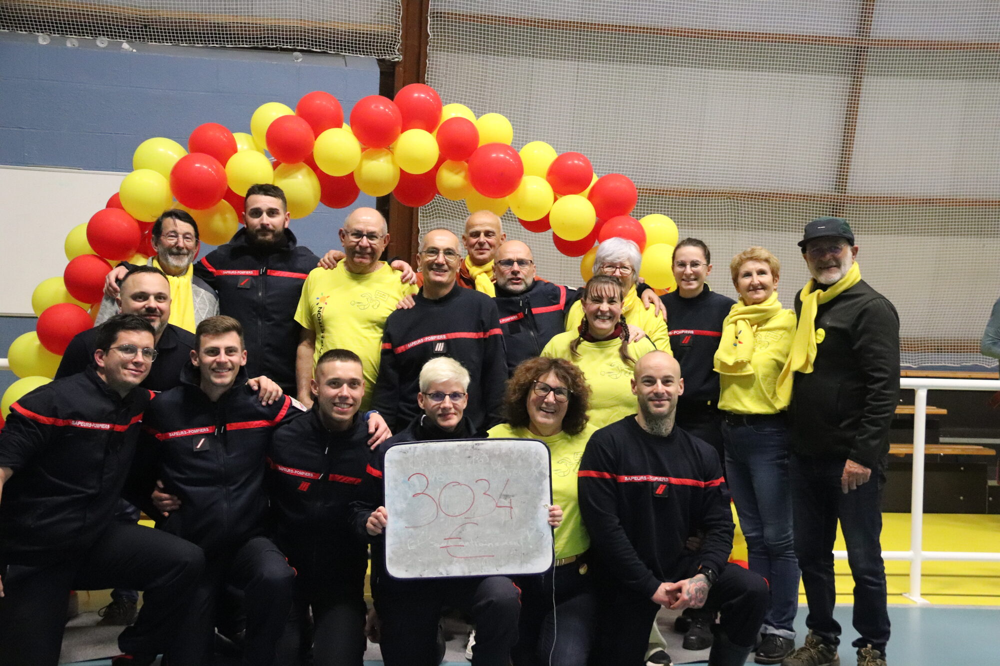 Équipe des sapeurs-pompiers et de l'AFM Téléthon présentant le montant collecté lors de la 1ère édition du Challenge Téléthon